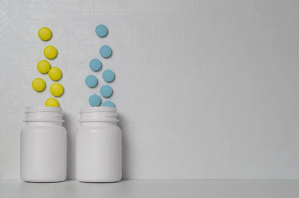 Жовті Сині Таблетки Ліками Або Вітамінами Вилітають Двох Білих Пластикових — стокове фото