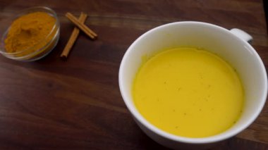 Sağlıklı Altın Süt Latte 'ye bir tutam zerdeçal baharat tozu ekleniyor