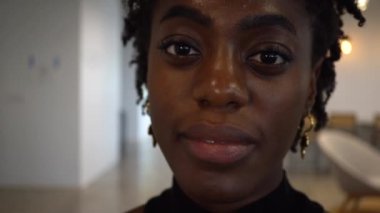 Genç bir Afrikalı Amerikalı kadının portresi gülümsüyor.