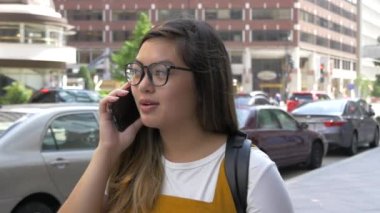 Şehirdeki hippi kahve dükkanına gidip gelirken telefonda konuşuyor.