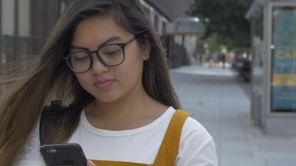 Gen Z亚洲妇女在城市人行道上用电话发短信 — 图库视频影像