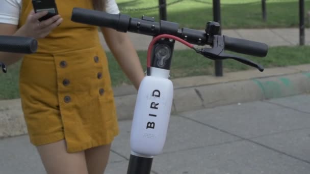 2019年8月 华盛顿特区 年轻女子在城市中解锁鸟类滑板车 — 图库视频影像