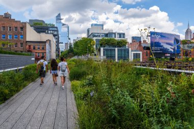 New York, ABD, Ağustos 2022 - Yaz günü High Line gezinti güvertesinde yürüyen insanlar