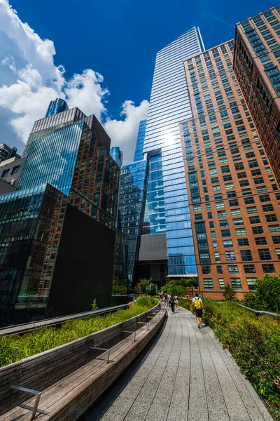 New York, ABD, Ağustos 2022 - Yaz günü High Line gezinti güvertesinde yürüyen insanlar