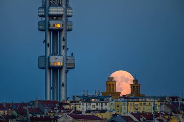 Prag şehrinin üzerinde Zizkov TV kulesiyle yükselen dolunay..