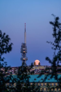 Prag şehrinin üzerinde Zizkov TV kulesiyle yükselen dolunay..