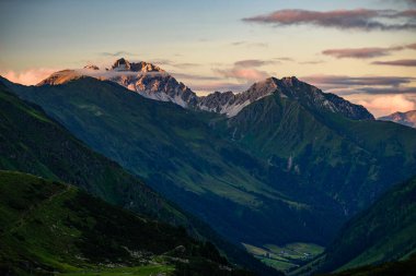 Kalkkogel dağ sırasının en yüksek zirvesi Schlicker Seespitze ve Hoher Burgstall Stubai Alplerinde turuncu günbatımı ışığında. 