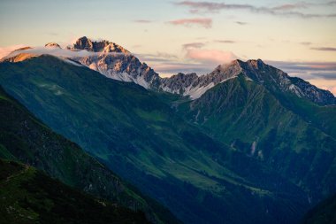 Kalkkogel dağ sırasının en yüksek zirvesi Schlicker Seespitze ve Hoher Burgstall Stubai Alplerinde turuncu günbatımı ışığında. 
