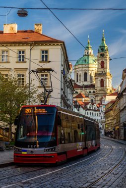 Prag, Çek Cumhuriyeti, Nisan 2022 - Karmelitska caddesinden geçen bir tramvay St. Nicholas Kilisesi 'ne doğru gidiyor.