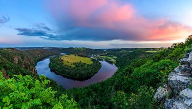 Çek Cumhuriyeti 'nin Solenicka Podkova kentindeki Vltava nehrinin üzerinde pembe bir günbatımı. 
