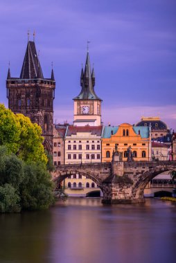Alacakaranlıkta Prag 'daki Vltava Nehri üzerindeki Charles Köprüsü.  