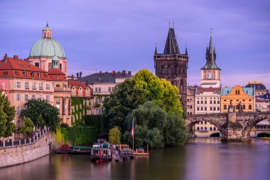 Alacakaranlıkta Prag 'daki Vltava Nehri üzerindeki Charles Köprüsü.  