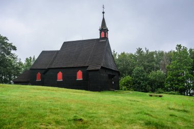 Bulutlu bir günde Beskydy dağlarında Mala Prasiva tepesinde ahşap bir kilise..