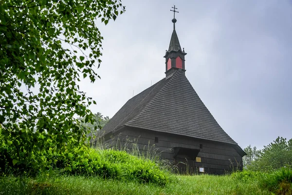 stock image A wooden church on top of Mala Prasiva in Beskydy mountains during a cloudy day.