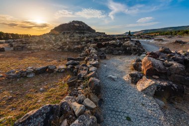 UNESCO world heritage site Su Nuraxi di Barumini on Sardinia island during sunset.  clipart