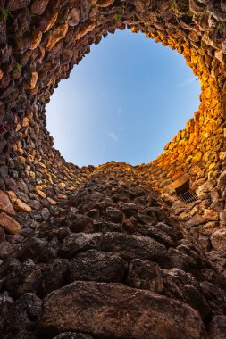 Inside of the bronze age fort UNESCO world heritage site Su Nuraxi di Barumini on Sardinia island during sunset.  clipart