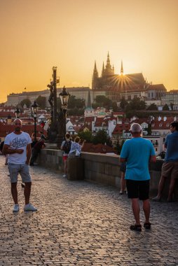 Prag, Çek Cumhuriyeti, 21.6.2021 - Charles Köprüsü 'ndeki yaz gündönümü gününde Prag kalesinin hemen arkasında batan güneş