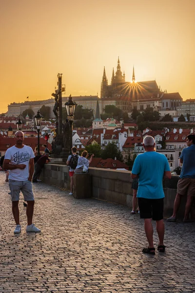 Prag, Çek Cumhuriyeti, 21.6.2021 - Charles Köprüsü 'ndeki yaz gündönümü gününde Prag kalesinin hemen arkasında batan güneş