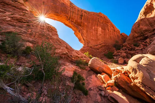 ABD 'nin Utah eyaletinin Moab kentindeki Arches Ulusal Parkı' ndaki Kuzey Pencere Kemeri 'nde parlayan mercek parlıyor..