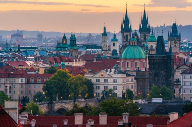 The cityscape of Prague listed in Unesco with Church of Our Lady before Tyn and Charles Bridge in the dawn.  clipart