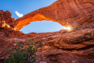 Güneş yıldızı, Moab, Utah, ABD 'deki Arches Ulusal Parkı' ndaki Kuzey Pencere Kemeri 'nden parlıyor..