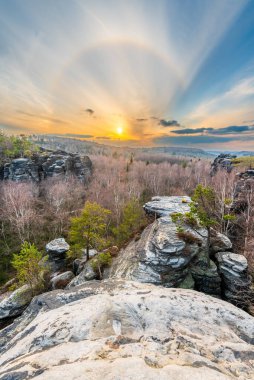 The Tisa Rocks or Tisa Walls in the Elbe Sandstone Mountains of Czech Republic in the late autumn sunset with the halo effect. clipart