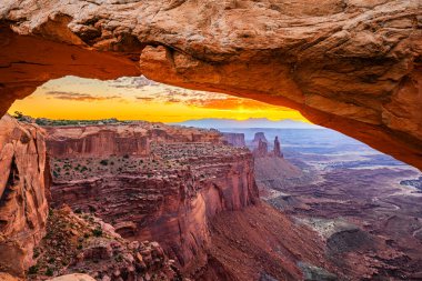 Utah 'ta Moab yakınlarındaki Kanyonlar Ulusal Parkı' nın Gök Bölgesi 'ndeki Mesa Kemeri' nde renkli bir sabah güneşi doğuyor..