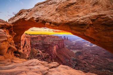 Utah 'ta Moab yakınlarındaki Kanyonlar Ulusal Parkı' nın Gök Bölgesi 'ndeki Mesa Kemeri' nde renkli bir sabah güneşi doğuyor..