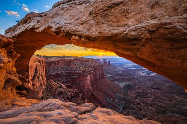Utah 'ta Moab yakınlarındaki Kanyonlar Ulusal Parkı' nın Gök Bölgesi 'ndeki Mesa Kemeri' nde renkli bir sabah güneşi doğuyor..