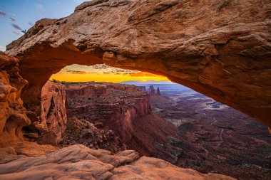 Utah 'ta Moab yakınlarındaki Kanyonlar Ulusal Parkı' nın Gök Bölgesi 'ndeki Mesa Kemeri' nde renkli bir sabah güneşi doğuyor..