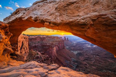 Utah 'ta Moab yakınlarındaki Kanyonlar Ulusal Parkı' nın Gök Bölgesi 'ndeki Mesa Kemeri' nde renkli bir sabah güneşi doğuyor..