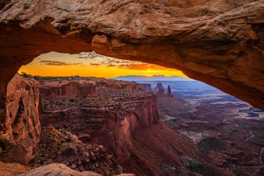Utah 'ta Moab yakınlarındaki Kanyonlar Ulusal Parkı' nın Gök Bölgesi 'ndeki Mesa Kemeri' nde renkli bir sabah güneşi doğuyor..