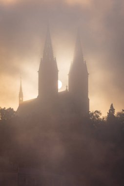 Vysehrad Bazilikası sabahın erken saatlerinde sis ve sonbaharda UNESCO şehir sitesi Prag 'da bulutlar.