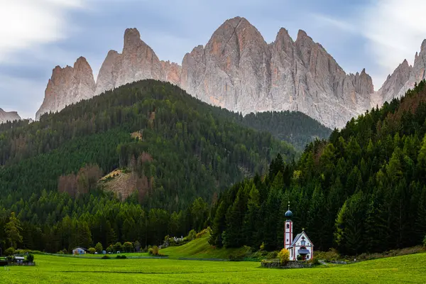 Santa Magdalena 'daki St. John Kilisesi UNESCO yerleşim yerindeki dağlarda sabahın erken saatlerinde Kuzey İtalya' da Dolomitler.