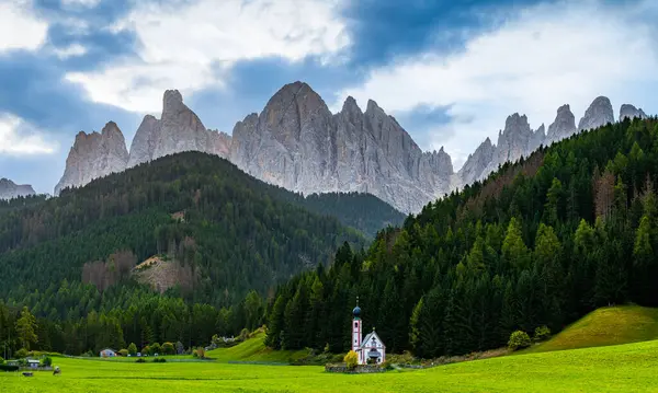 Santa Magdalena 'daki St. John Kilisesi UNESCO yerleşim yerindeki dağlarda sabahın erken saatlerinde Kuzey İtalya' da Dolomitler.
