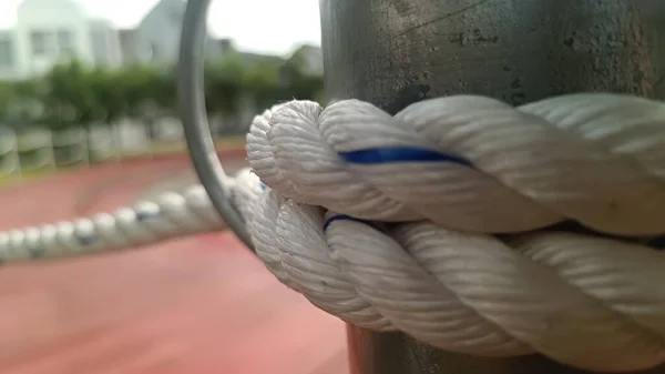 Gümüş renkli bir demire bağlanmış beyaz bir ip.