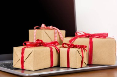 Laptop ve paketlenmiş hediye kutuları klavyede, kopyalama alanı. Çevrimiçi alışveriş kavramı