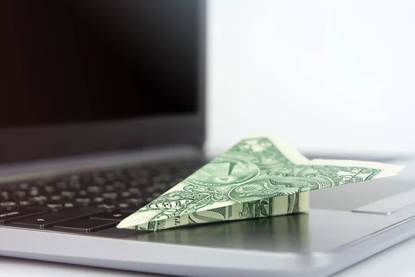Bir dolarlık uçak dizüstü bilgisayarda. Çevrimiçi iş kavramı