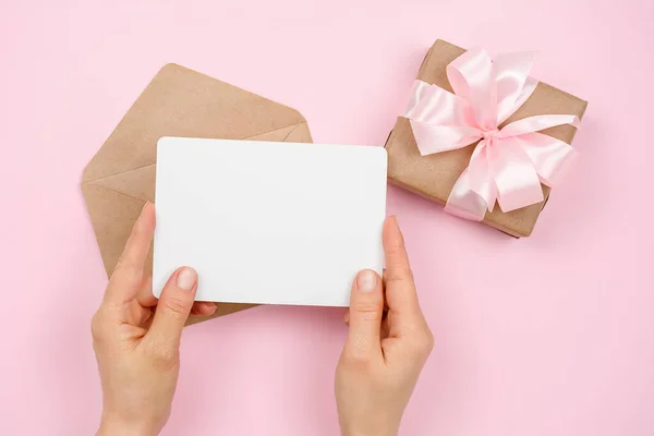 Жіноча Рука Тримає Порожню Білу Подарункову Картку Рожевому Тлі Конвертом — стокове фото
