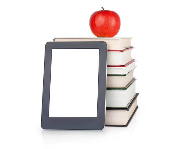 Üstünde beyaz elma olan ciltli kitap yığınının yanındaki e-kitap. Eğitim kavramı