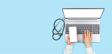 Kadın doktorun elleri boş ekranlı akıllı telefonu tutuyor ve mavi arka planda boş monitörlü dizüstü bilgisayar kullanıyor. Üst görünümü fotokopi alanı, steteskop da dizüstü bilgisayarın yanında. Teletıp kavramı