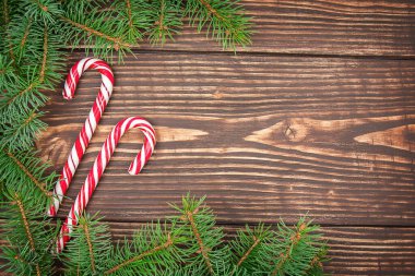 Noel ağacının köknar dalları ve şeker kamışları olan ahşap bir arka plan. Çerçeve bileşimi, kopyalama alanı ile üst görünüm