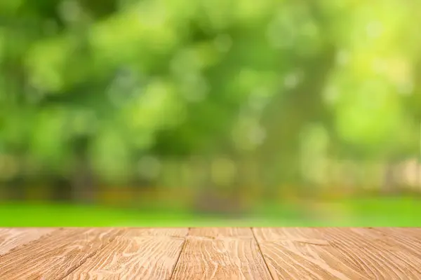 Bulanık yeşil park arka planında ahşap masa