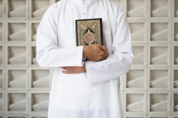 聖クルアーンアラビア語でアル クルアーンを意味する書道を手にします 聖クルアーンを持つムスリム男性 イスラーム的概念背景 — ストック写真