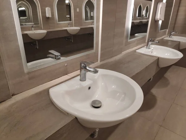 Round bathroom washing sink on marble stone surface with mirror interior in toilet