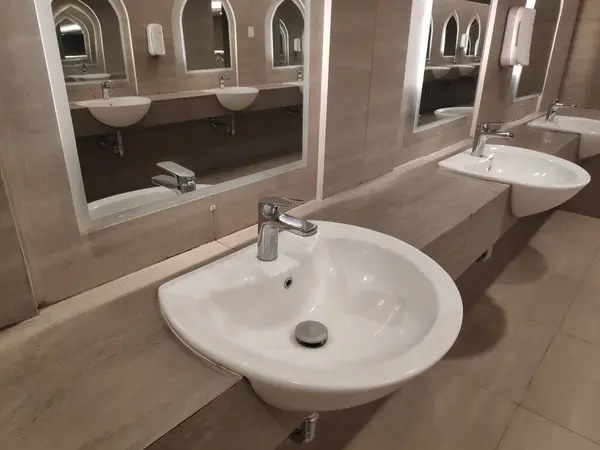 Yuvarlak banyo lavabosu mermer taş yüzeyde ve aynanın içi tuvalette.