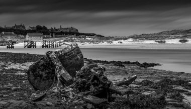 Eski bir gemi enkazı ile sahilin siyah beyaz fotoğrafı. 