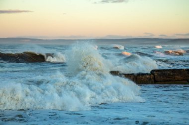 Fırtınalı deniz ve Lossiemouth limanı çevresindeki Morayshire kıyısı boyunca büyük dalgalar.