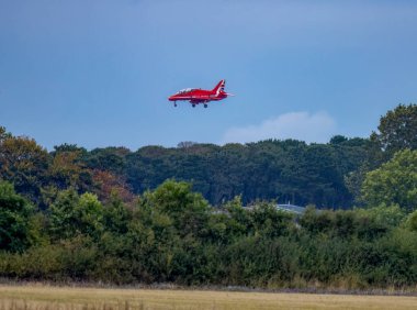 Kırmızı ok alçaktan uçuyor ağaçların üzerinden iniyor RAF Lossiemouth 'a