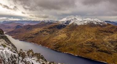 Stob Coire Easain ve Stob a 'Choire Mheadhoin tepeleri karla kaplı Treig Gölü